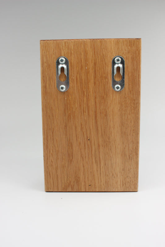 Rear of oak wall bottle opener showing keyhole mounting plates