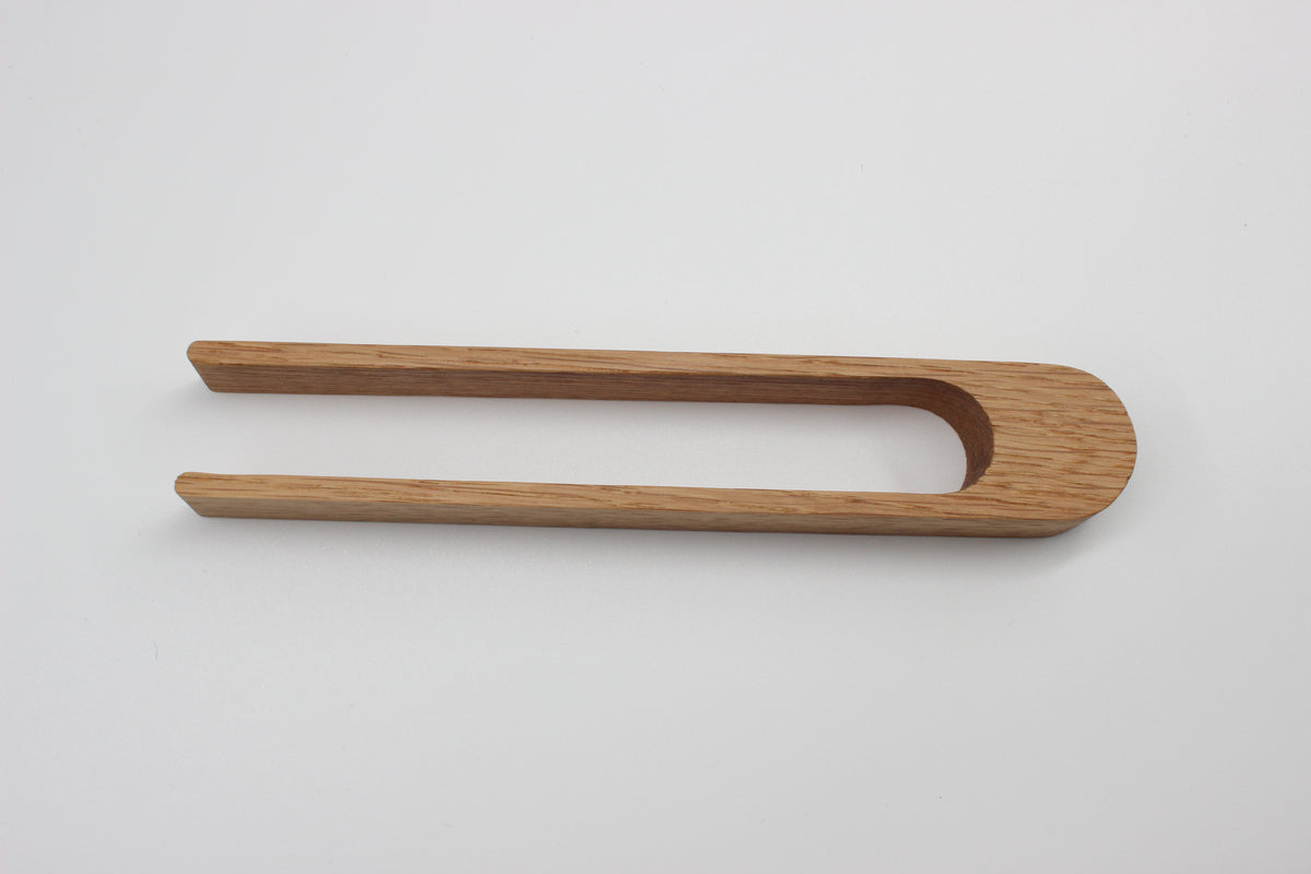 Side view of handmade oak toaster tongs