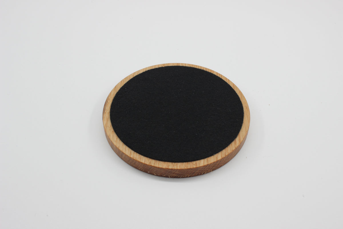 Underside of solid oak drinks coaster showing protective felt backing